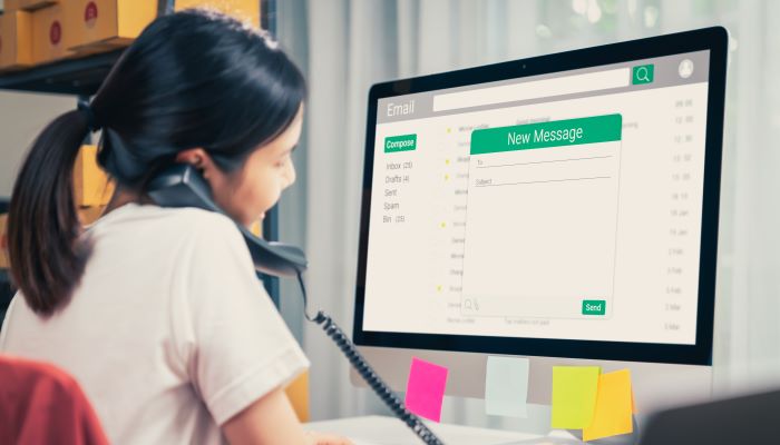 Woman using computer on table with new email message on laptop